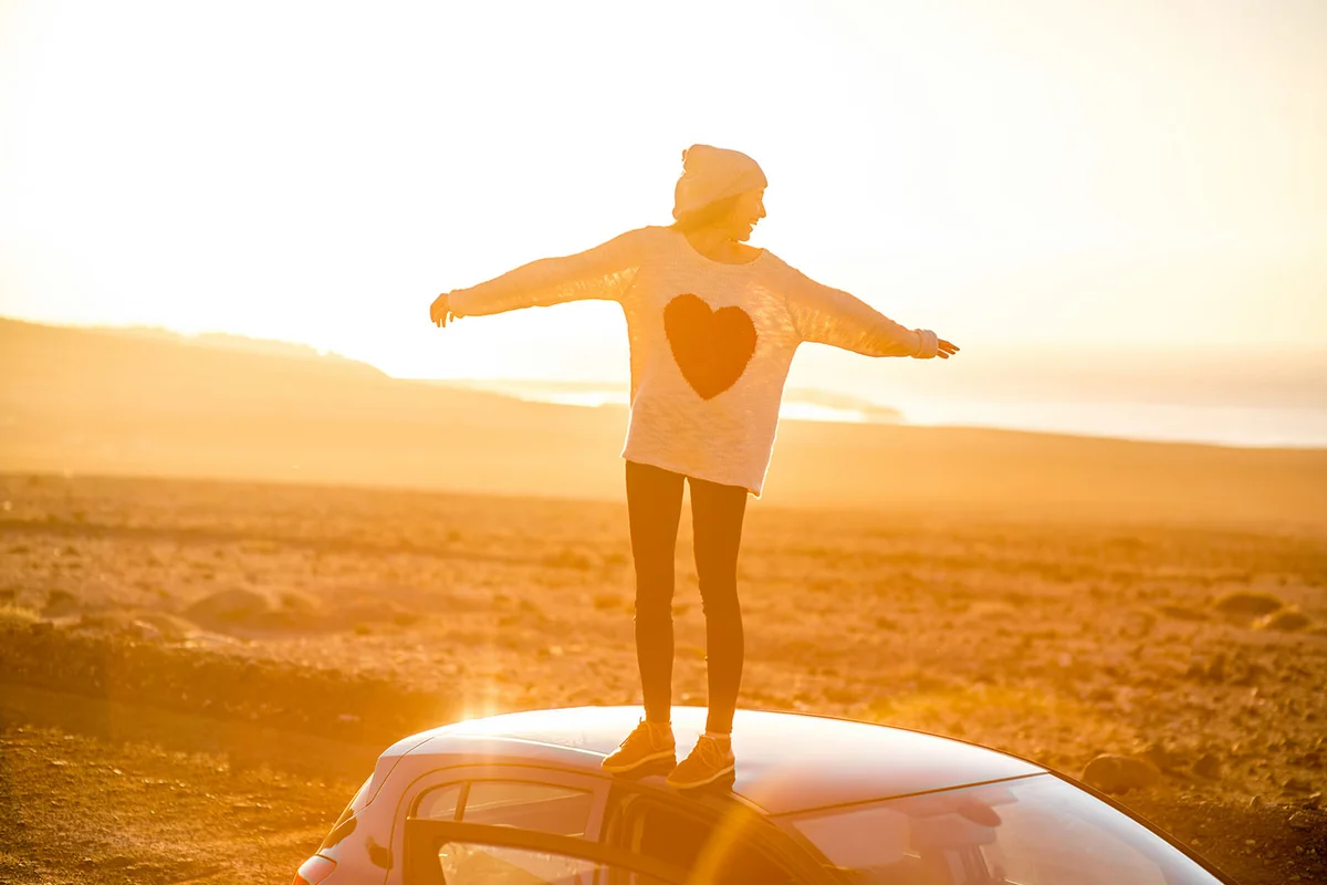 Woman enjoying desert roadtrip on the sunrise
