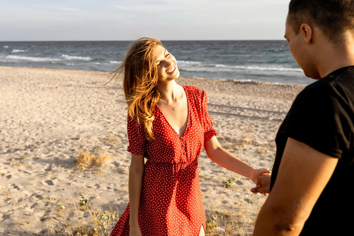 Carefree smiling man and woman hugging at the sea