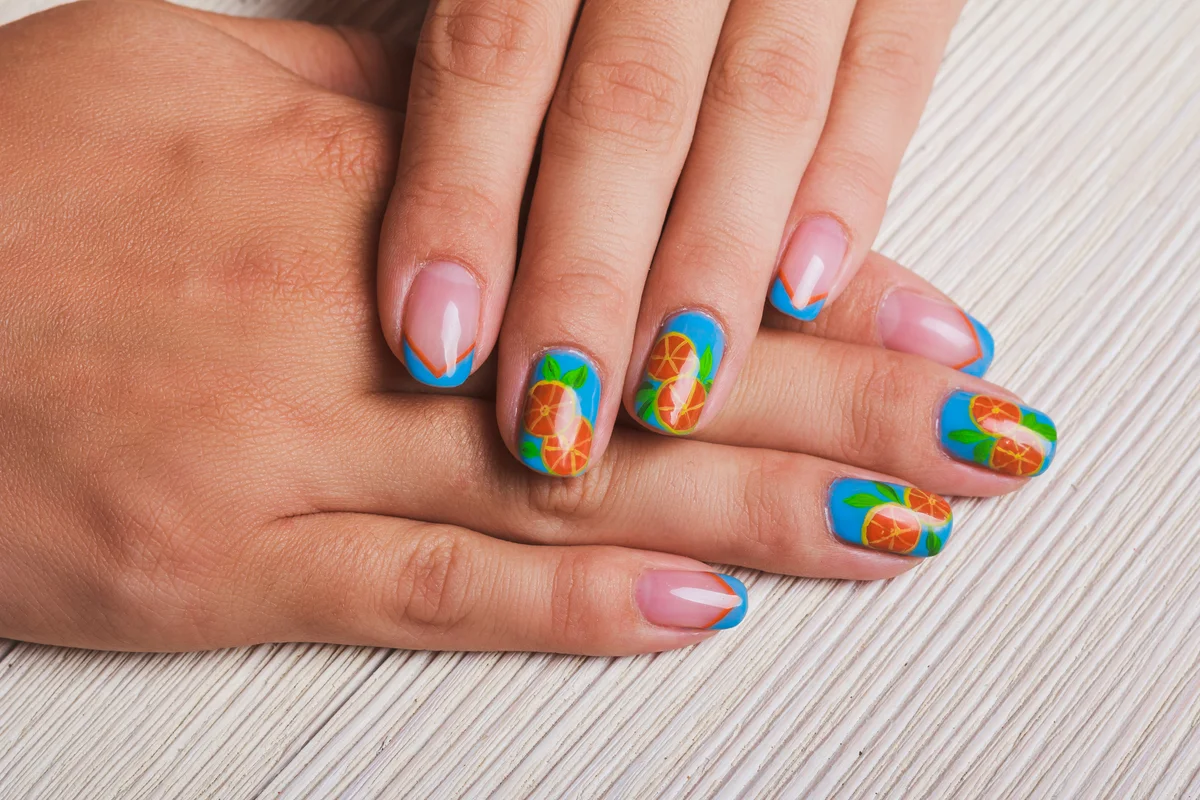 blue nail art with painted orange fruit