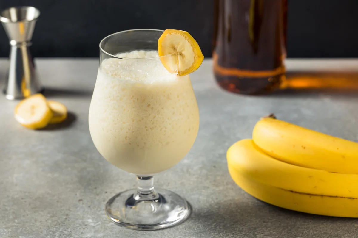 Banana daiquiri surrounded by its ingredients.