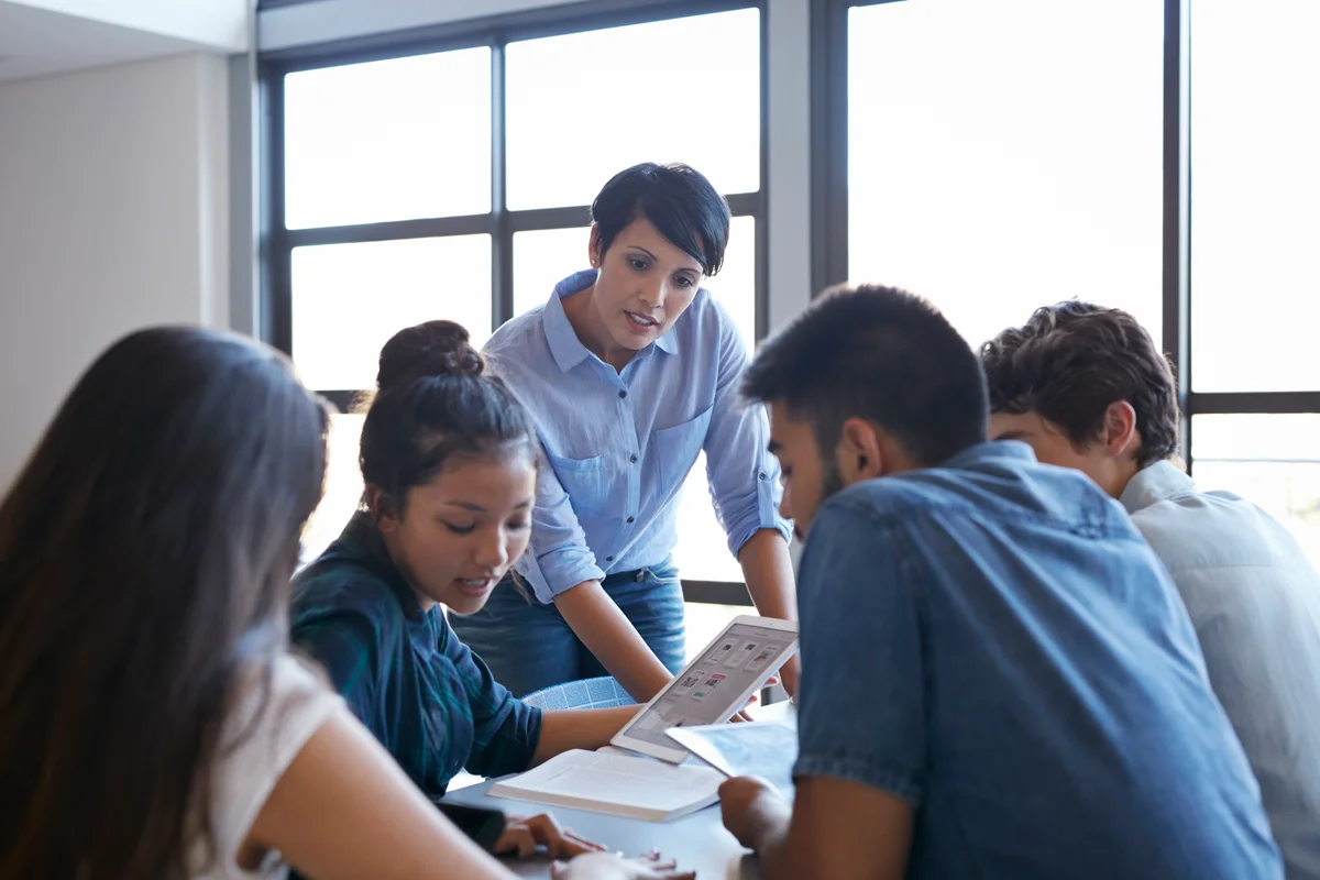 woman mentoring college students with tech