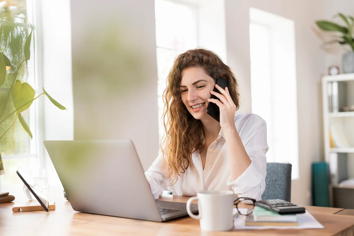 Contented female entrepreneur talking on smart phone