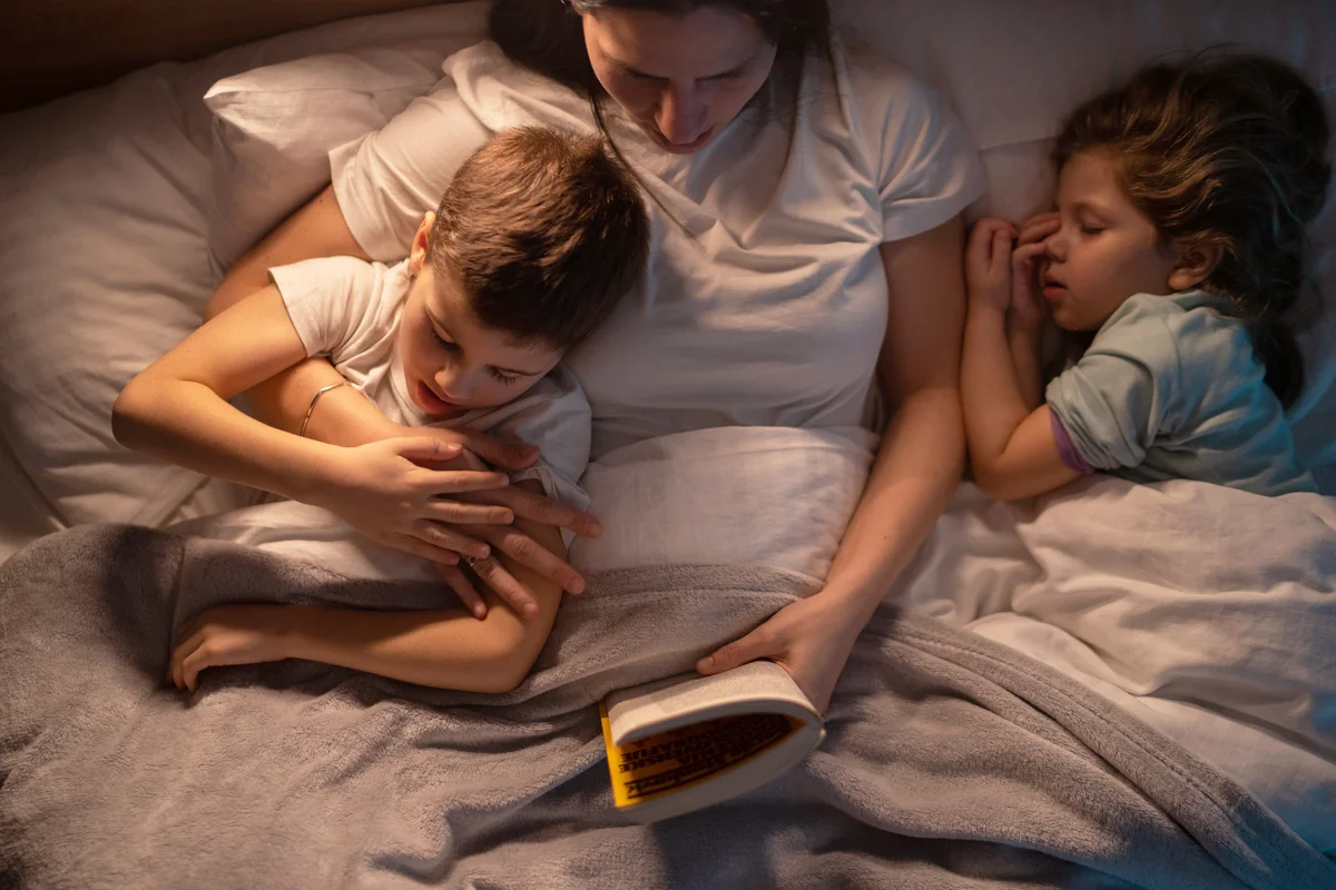 Mother and kids sharing bed