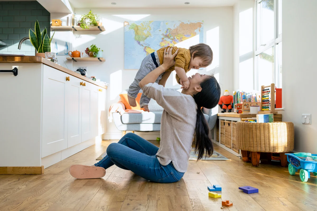 Mother sitting on the floor of a living room with her young boy