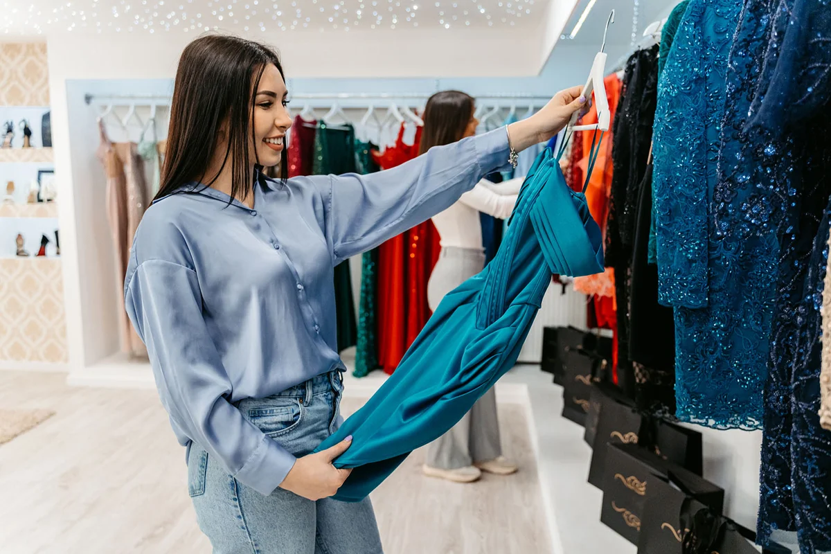 Beautiful young woman shopping for a prom dress in the boutique