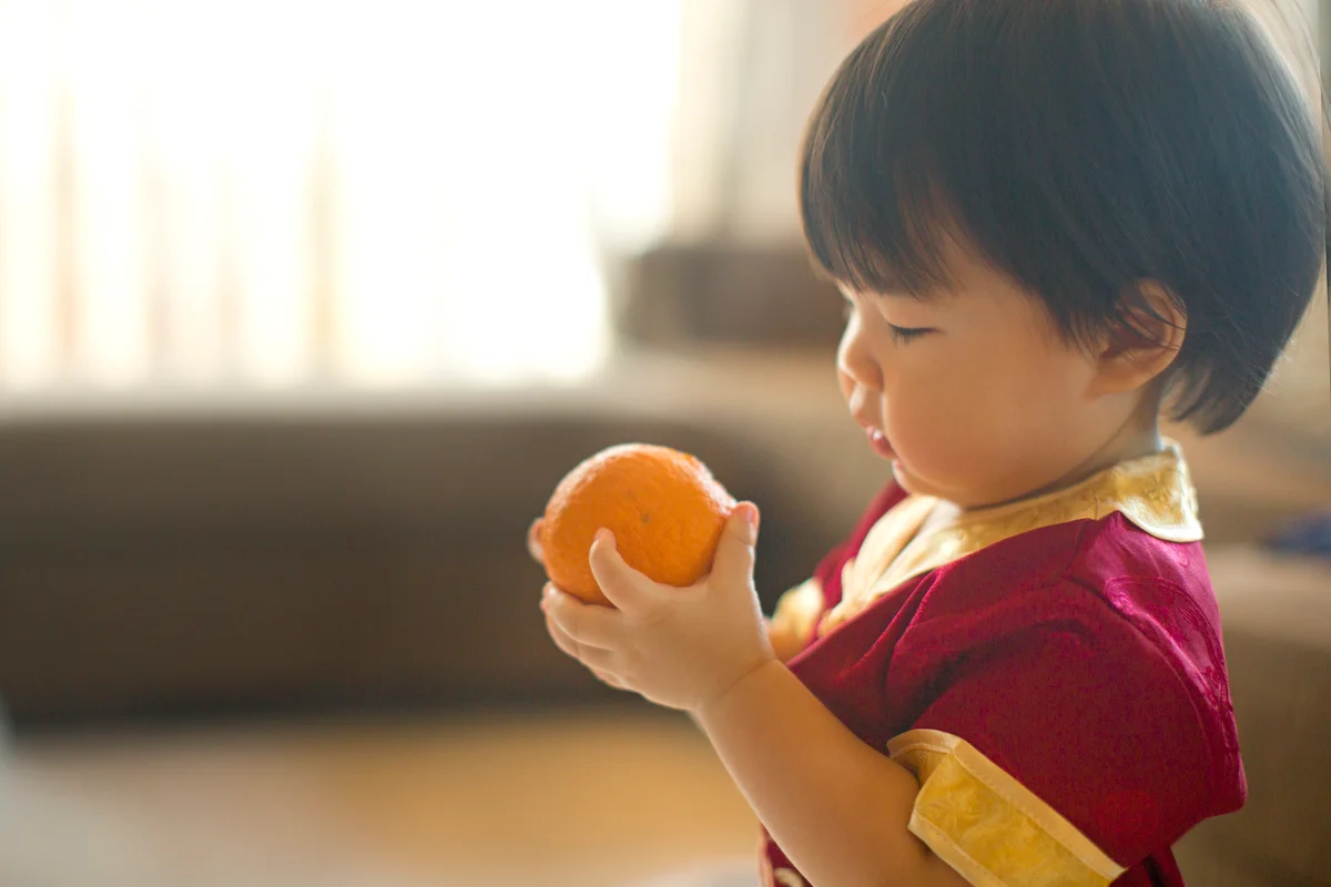 toddler with Mandarin orange