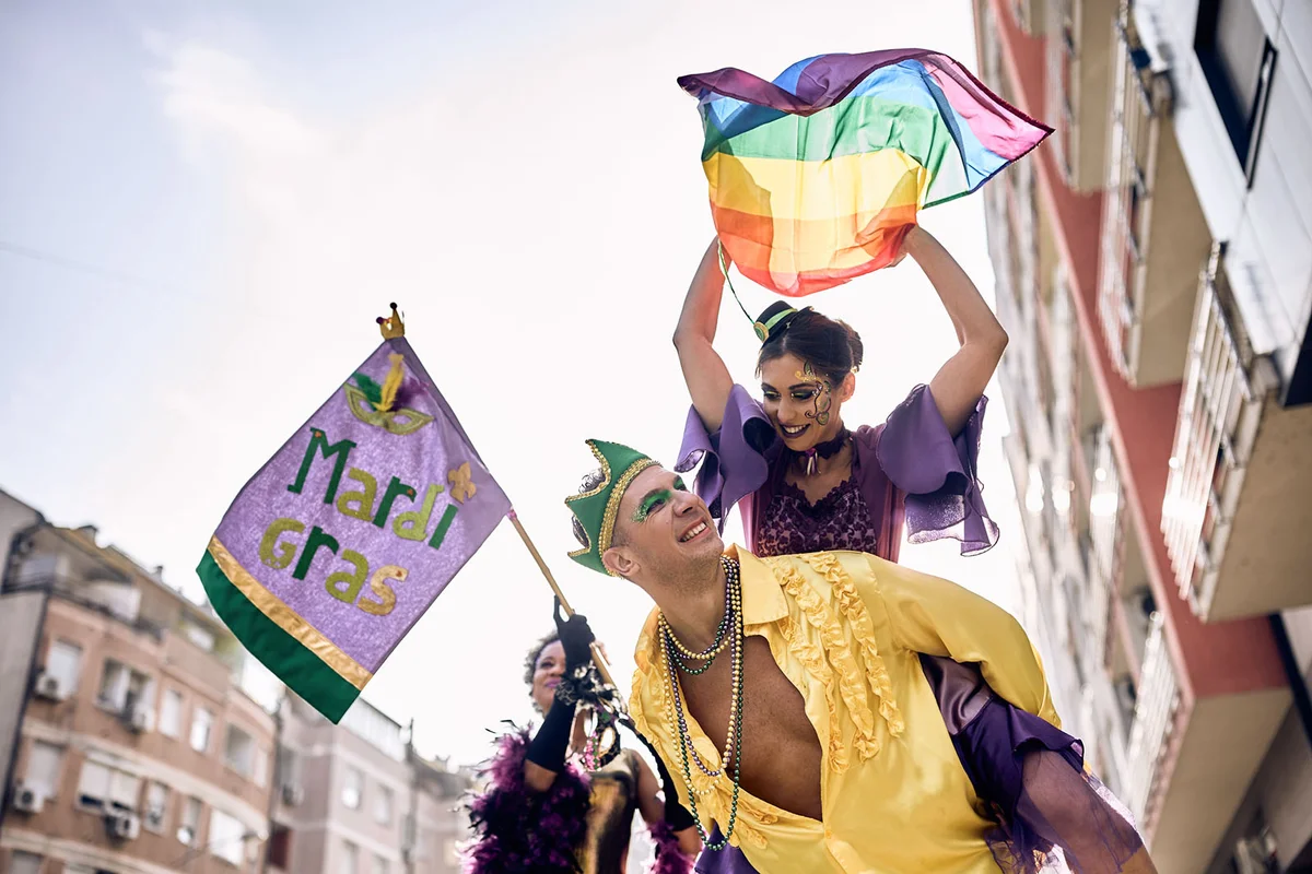 couple in piggybacking on street carnival during Mardi Gras celebration
