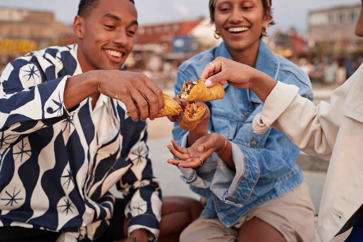 Friends toasting tacos on promenade