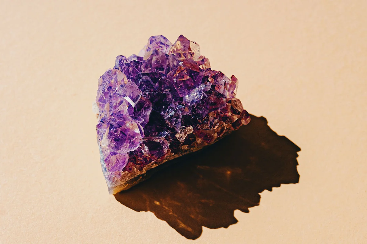 Amethyst crystal geode on a yellow