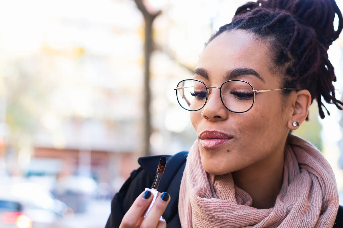 Young woman looking at lipstick