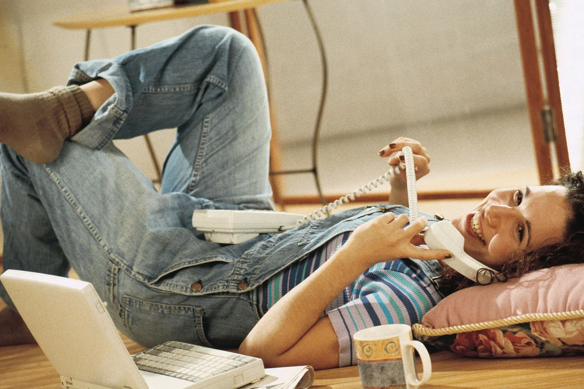 Woman laying on floor and talking on telephone