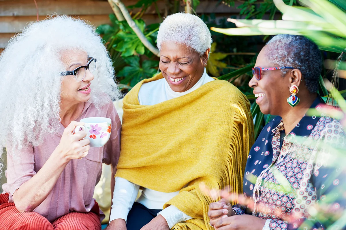 Three senior women talking in garden