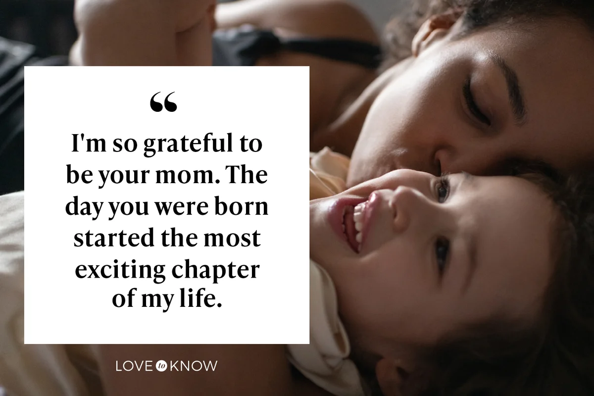 Mother kissing daughter on bed