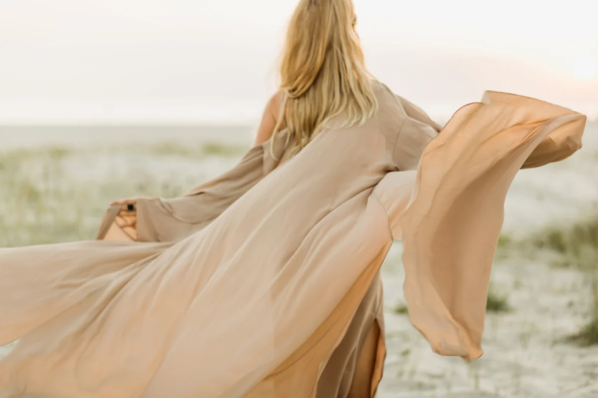 Woman wearing beige silk cape dress