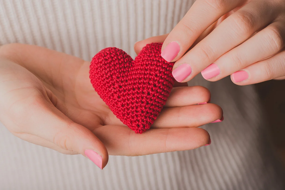 Hands holding a teddy heart