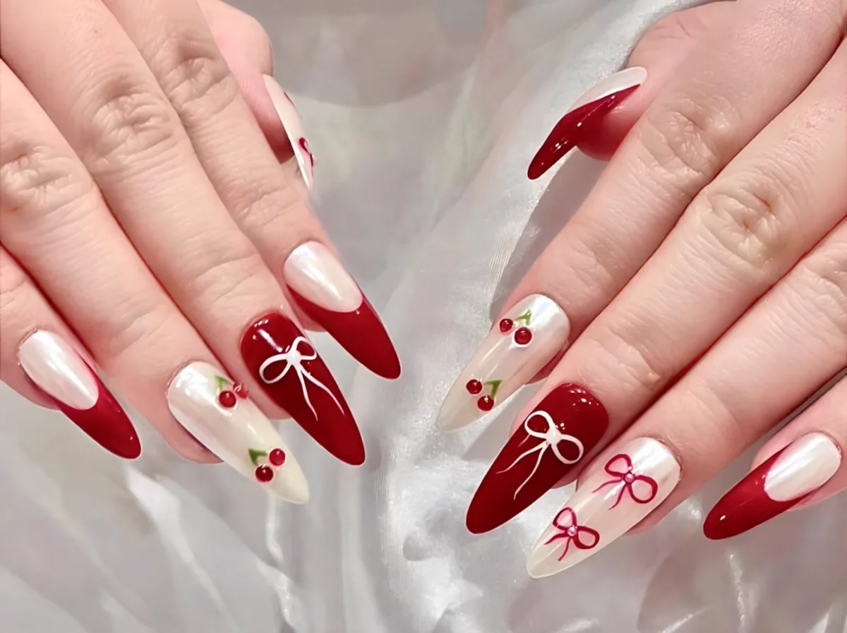 a pair of hands with red and white nail designs