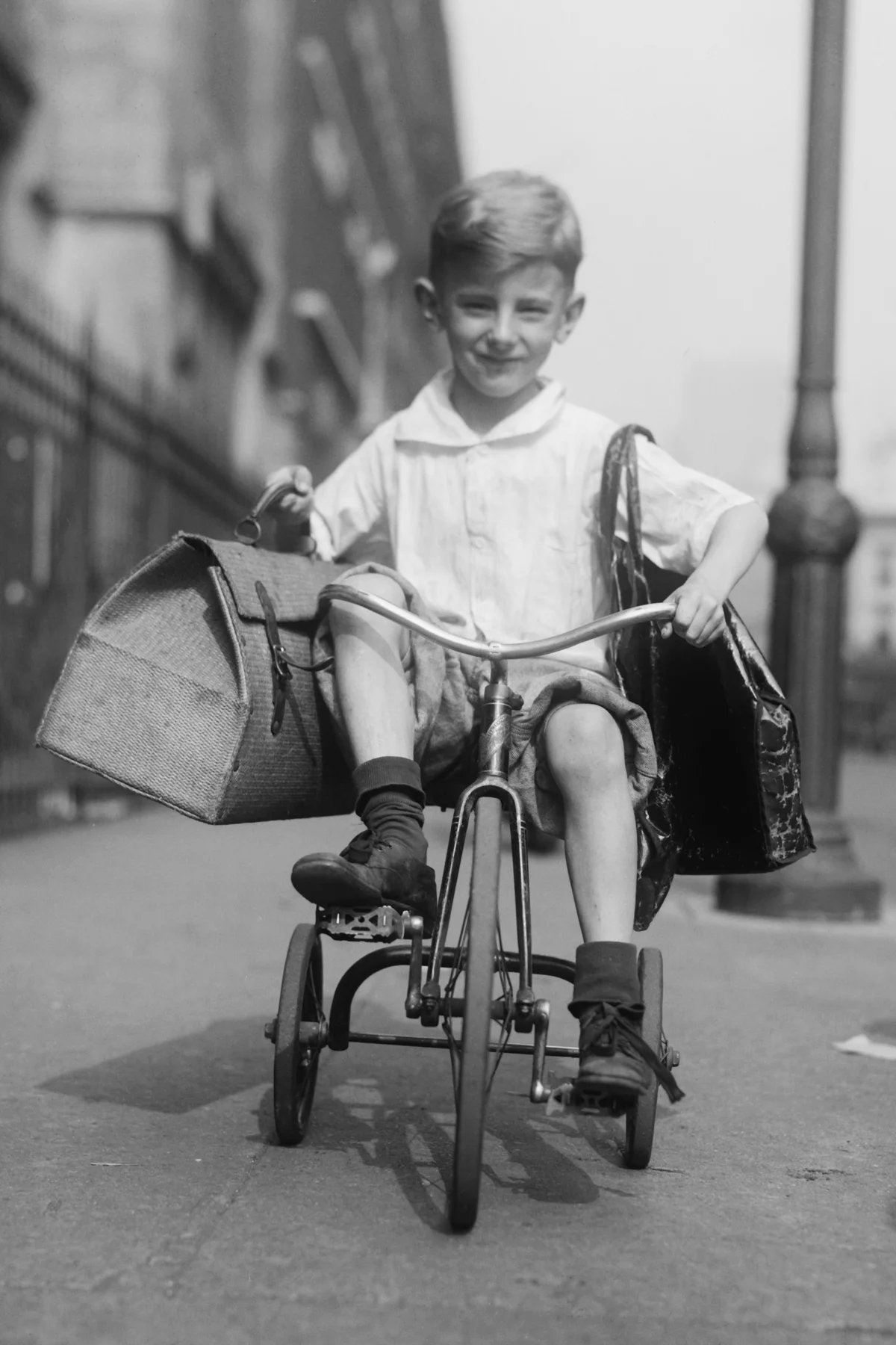 Youngster rides his tricycle on the sidewalks of New York City, c. 1920