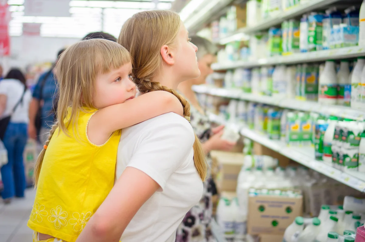 Teen mother with daughter in supermarket
