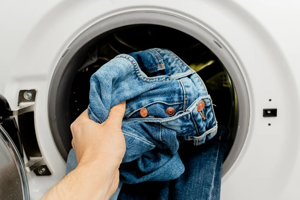 putting jeans in the laundry