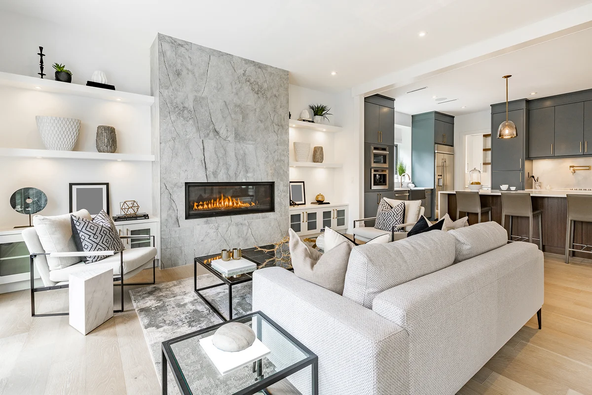 contemporary living room with open concept view through to dining room kitchen and a marble fireplace with gas fire