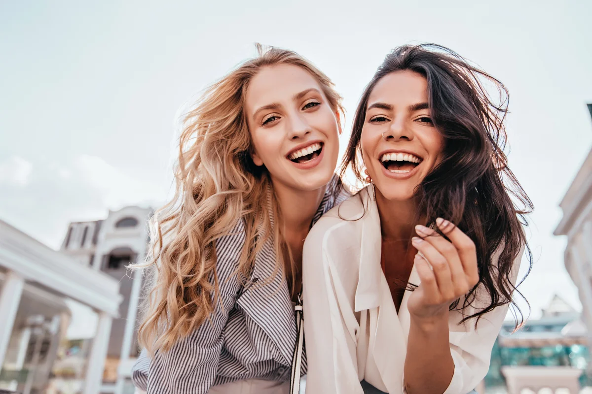 Long-haired women posing on sky background
