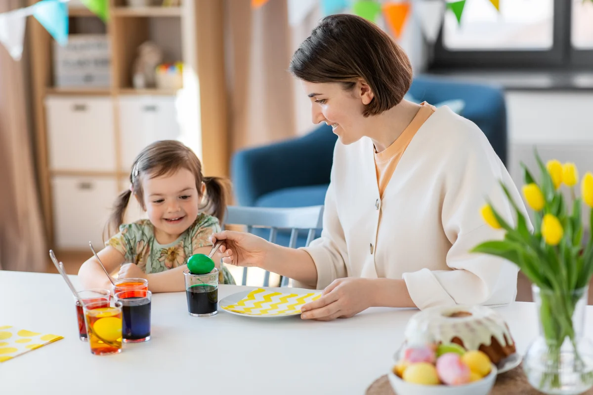 Mother and daughter dyeing easter eggs