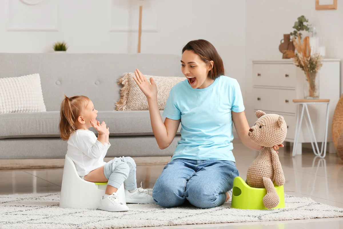 Mother potty training her little daughter at home