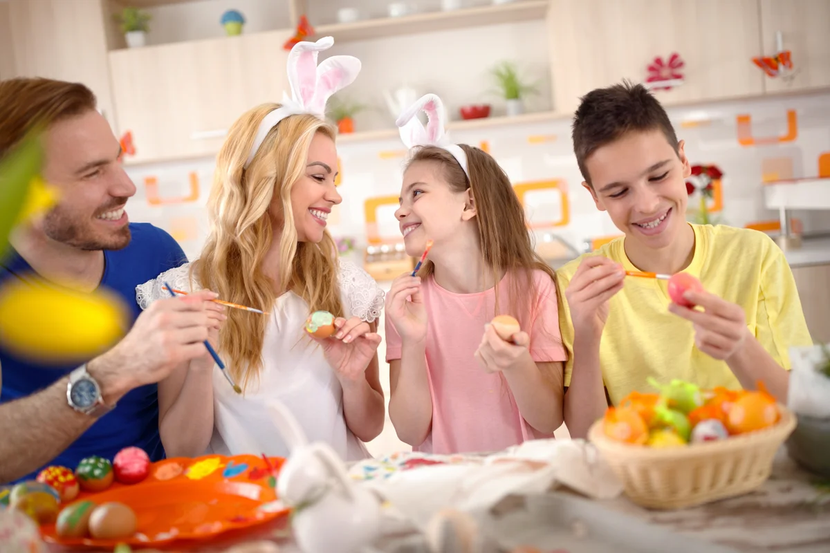 Family together painting Easter eggs