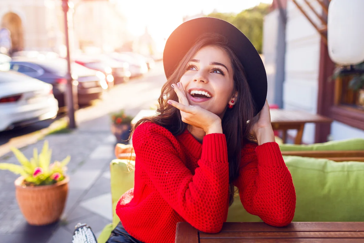 Woman in red sweater sitting in city cafe