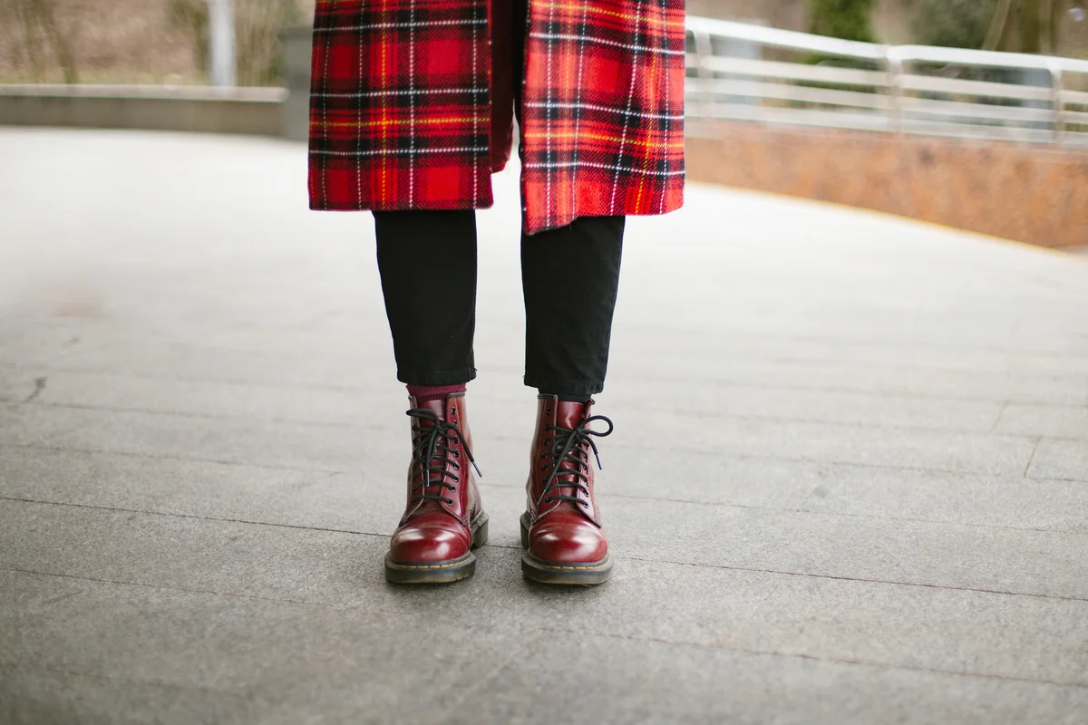 Woman wearing red trendy boots and trench coat