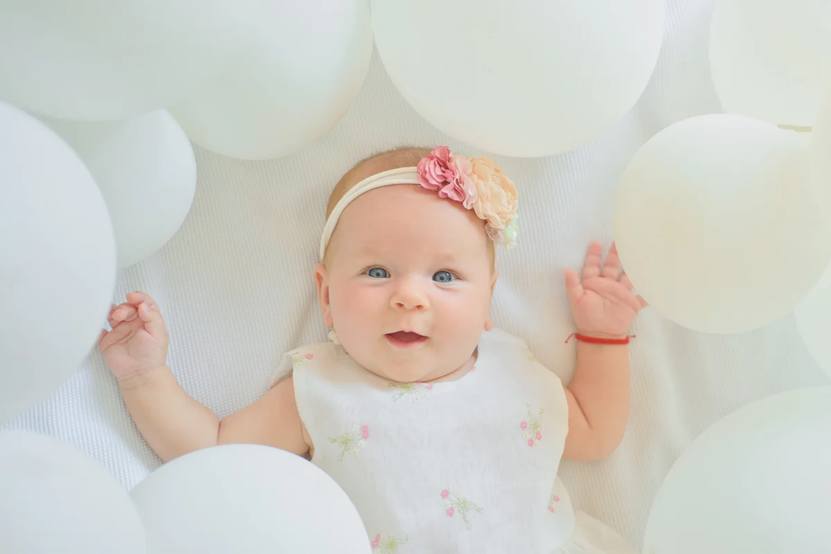 Baby girl with balloons and a flower headband