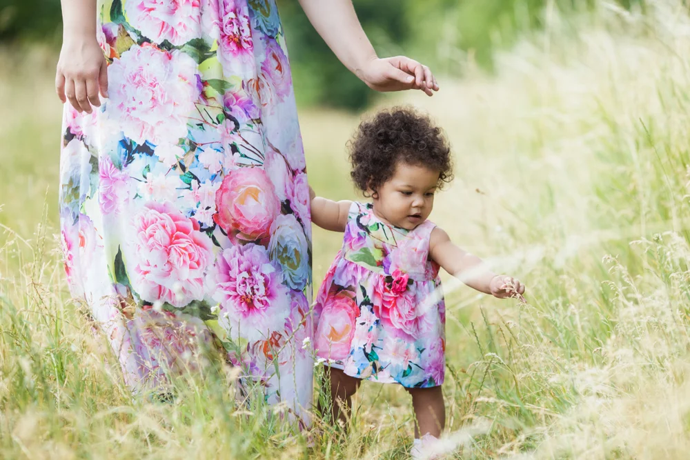 Baby girl in field with a flower dress