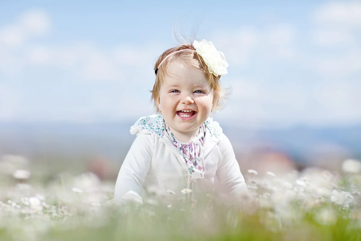 Baby girl sitting in a flower field