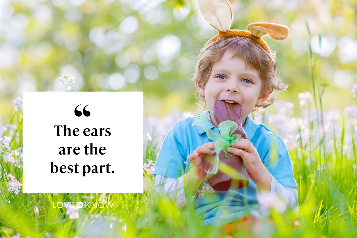 Happy little kid boy eating chocolate bunny ears