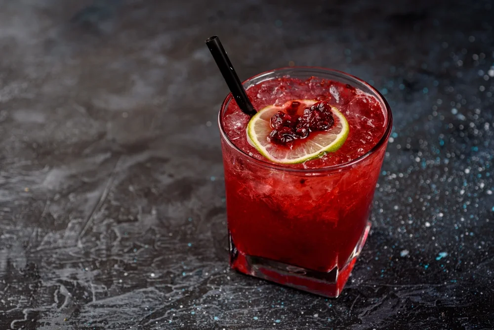 Negroni cocktail with raspberries on a grey background