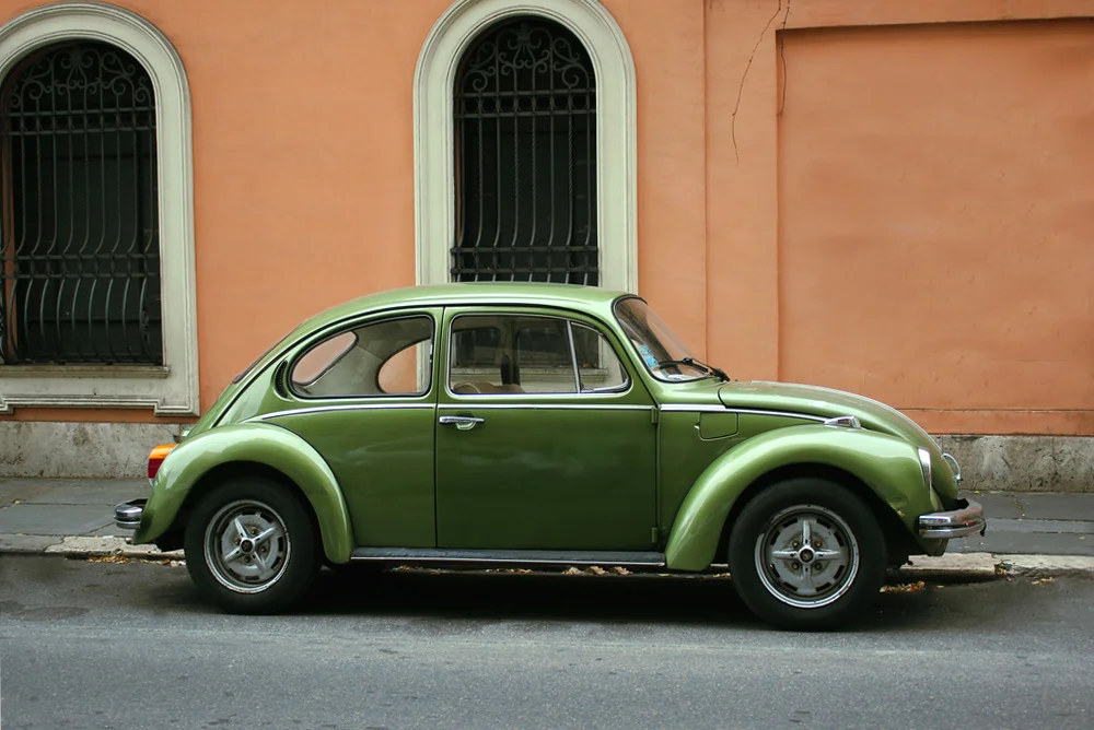 Green Volkswagen Beetle parked in a street