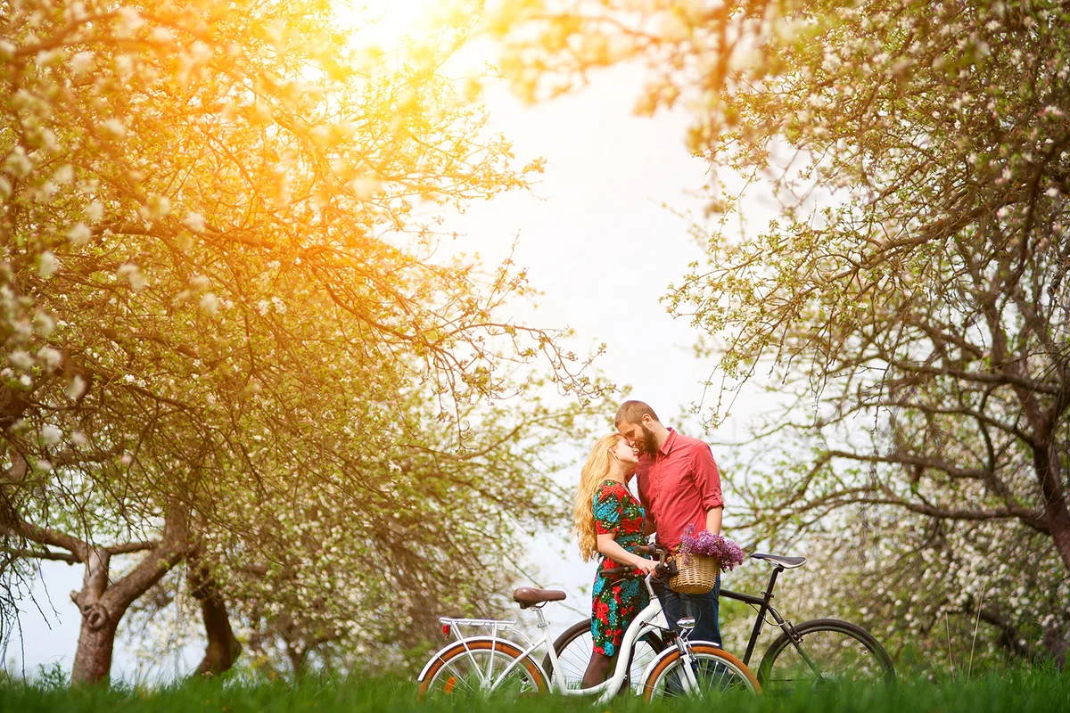 Couple with bikes surrounded by blooming trees