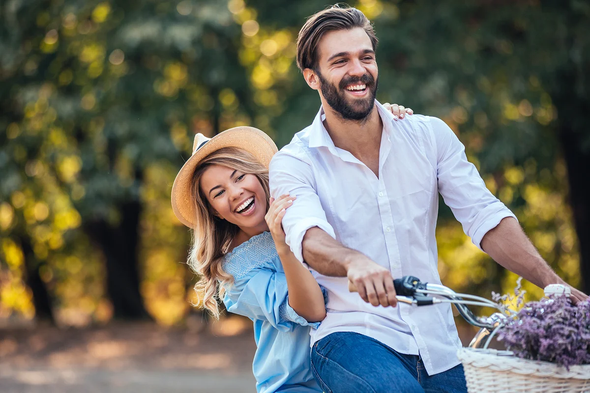 Young couple riding bike and enjoying a day at the park