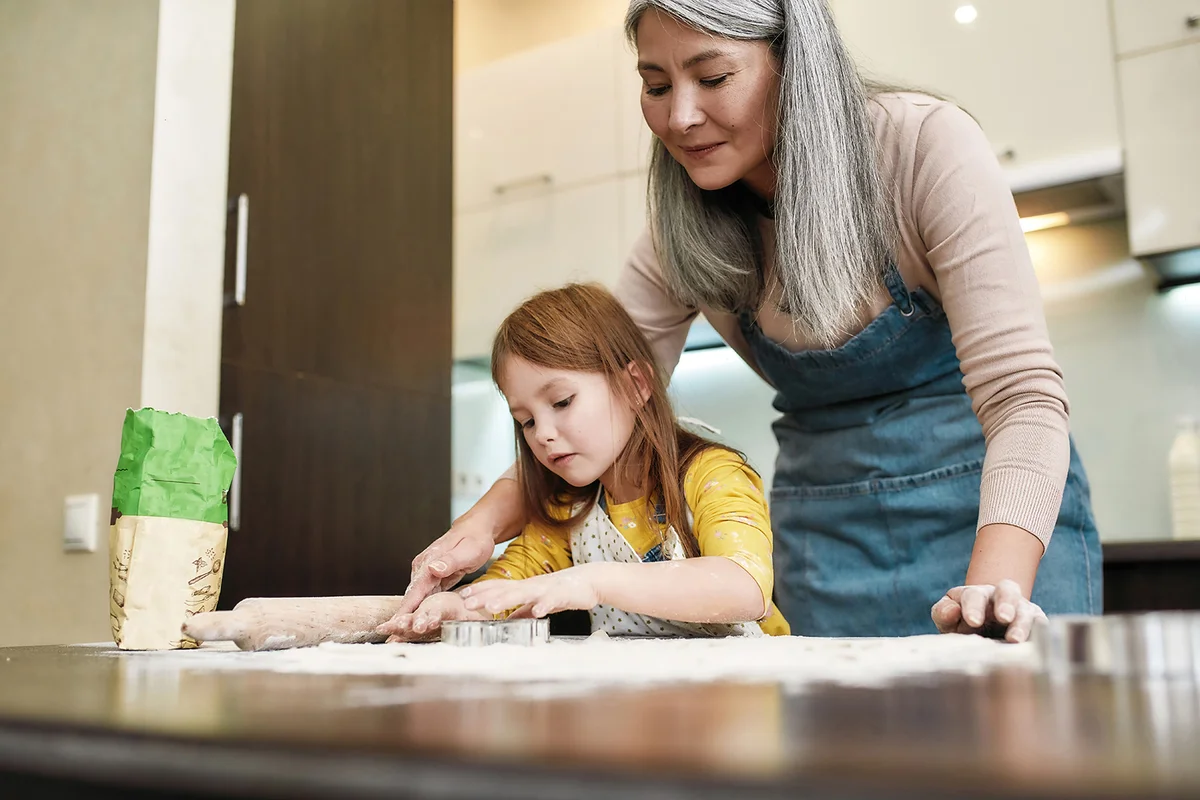 Senior and granddaughter baking cookies