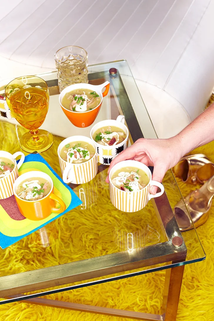 Male hand picking up a cup of pea soup at 70's party