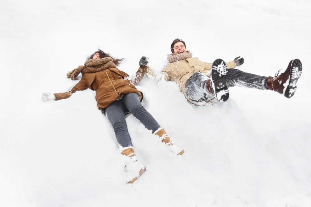 Couple making snow angels