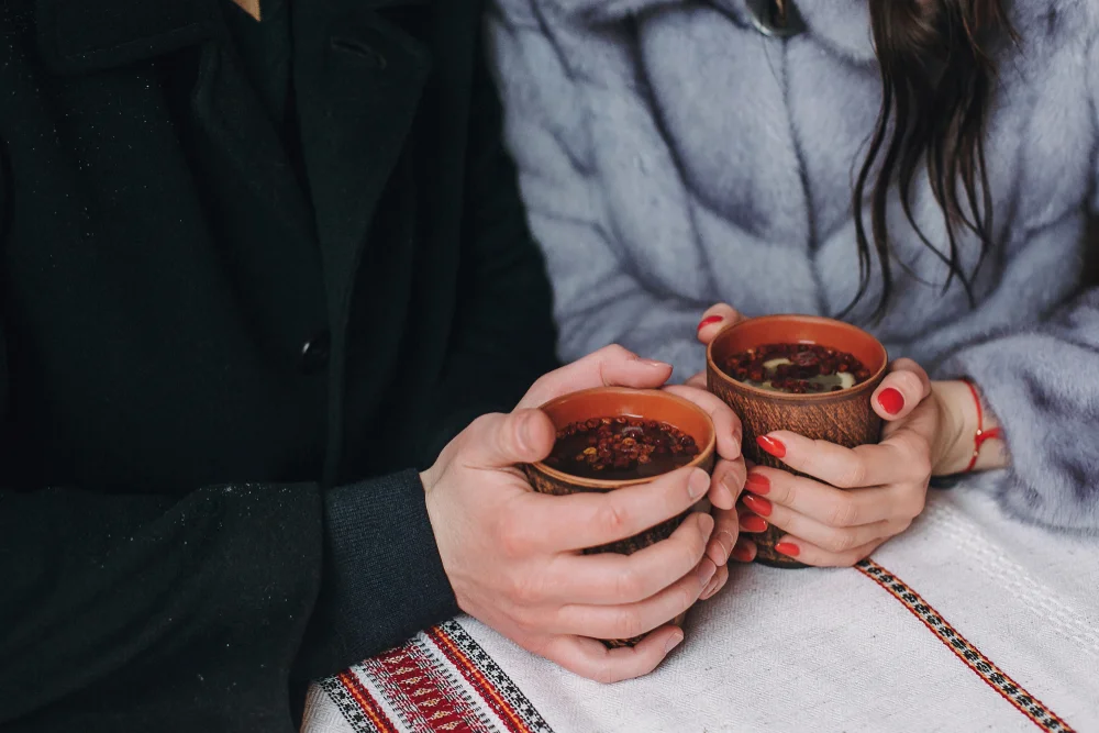 Couple's hands holding a warm drink in winter