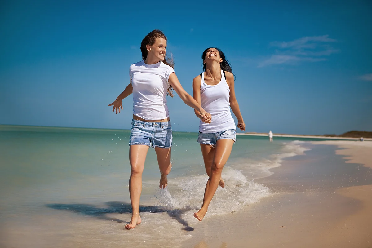 Lesbian couple running on the beach