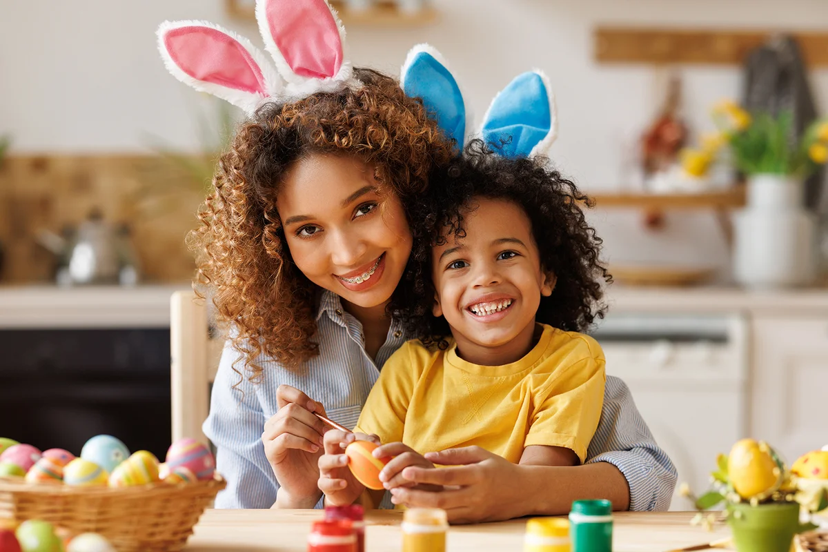 Mother and son decorate eggs with paints for Easter holidays