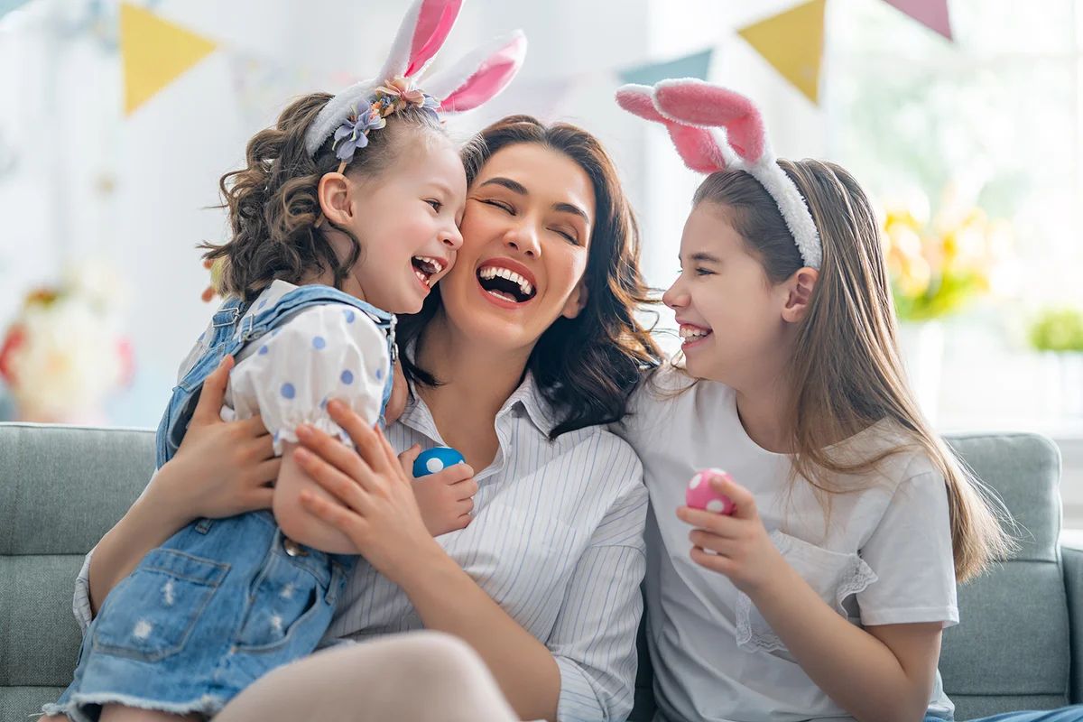 Mother and her daughters with painting eggs