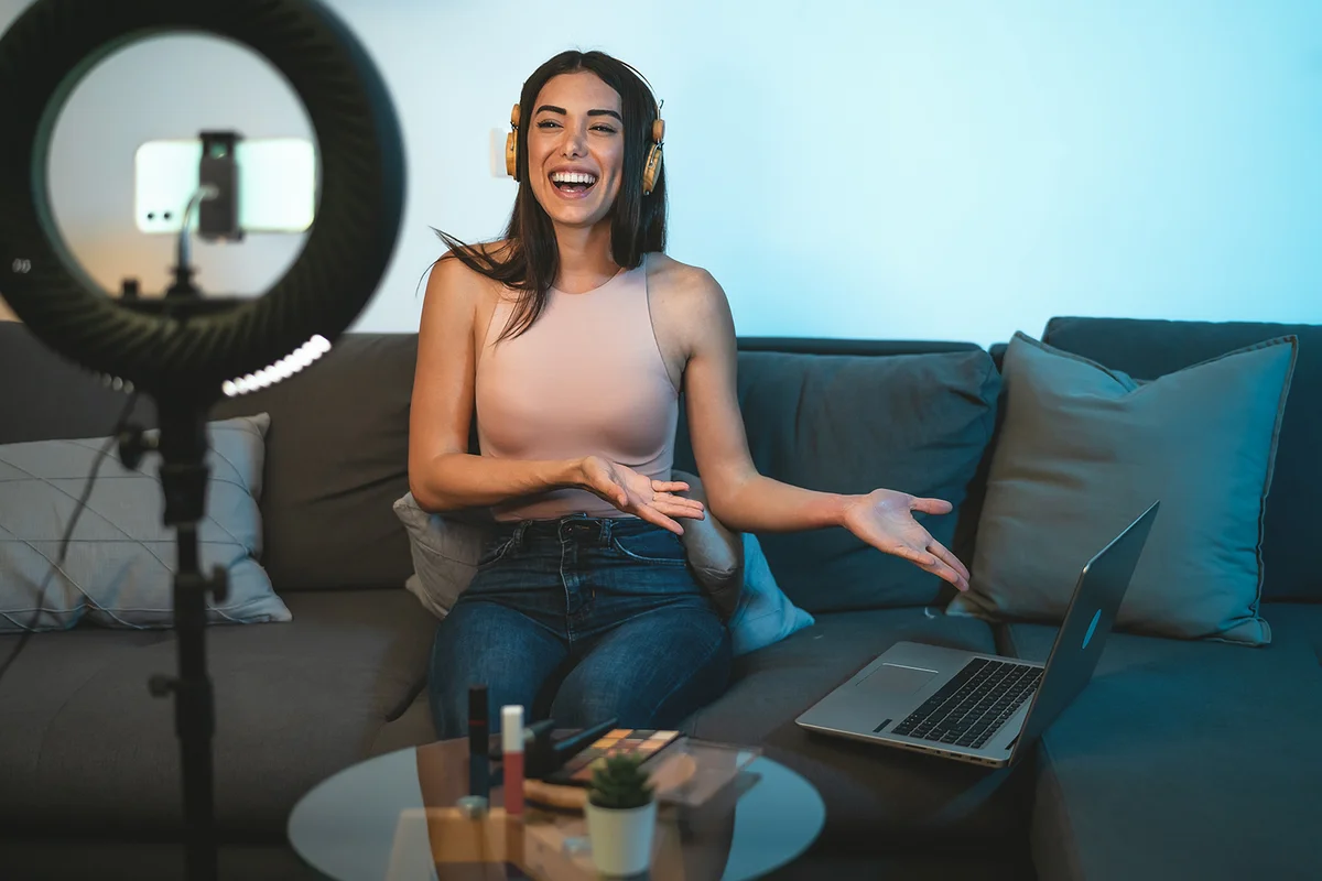 Female influencer vlogging online with smartphone cam