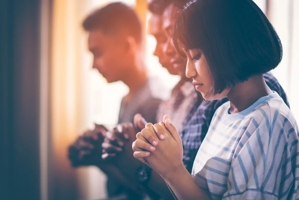 Group of young people praying together