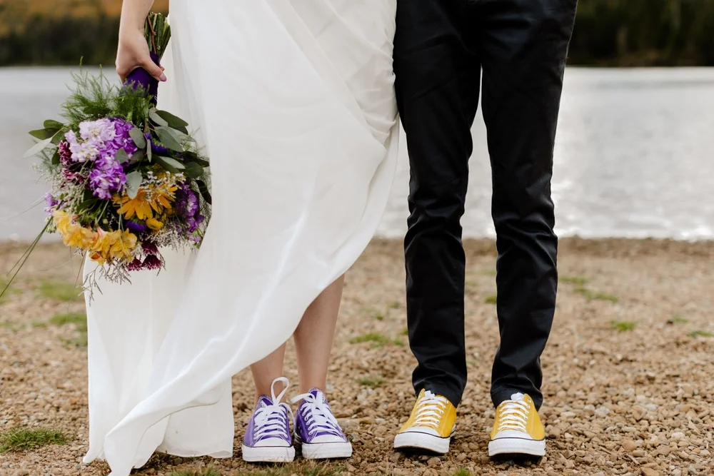 Detail of a bride and groom's legs wearing colorful sneakers