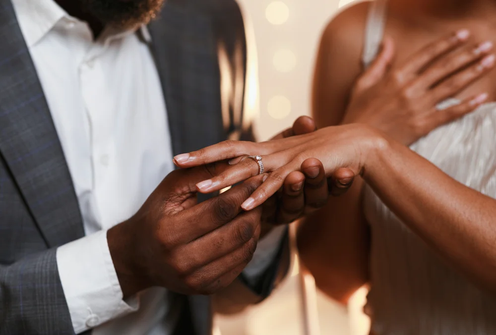 Close up of a man putting a ring in his bride's finger