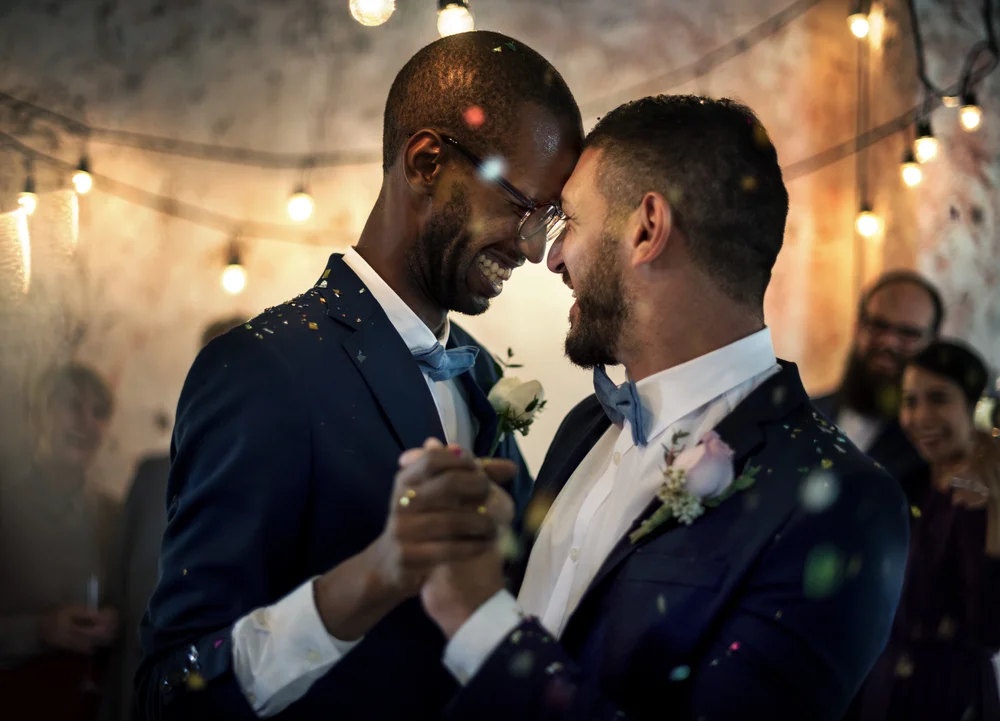 Newlywed gay couple dancing on their wedding party